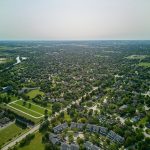 Aerial view of a large, uniform suburban residential neighbourhood in summer