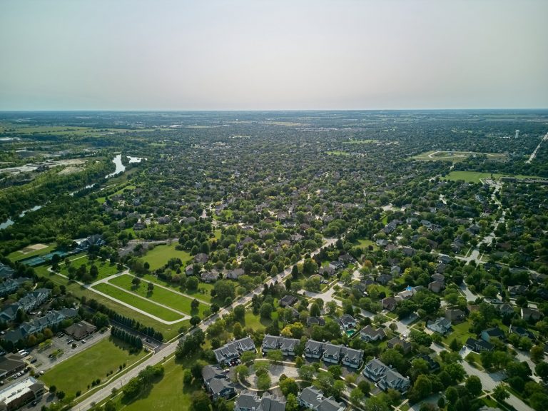 Aerial view of a large, uniform suburban residential neighbourhood in summer